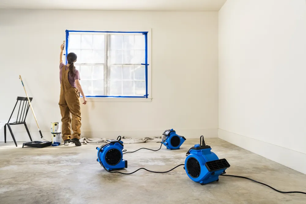 Technician preparing a room with air movers drying the floor